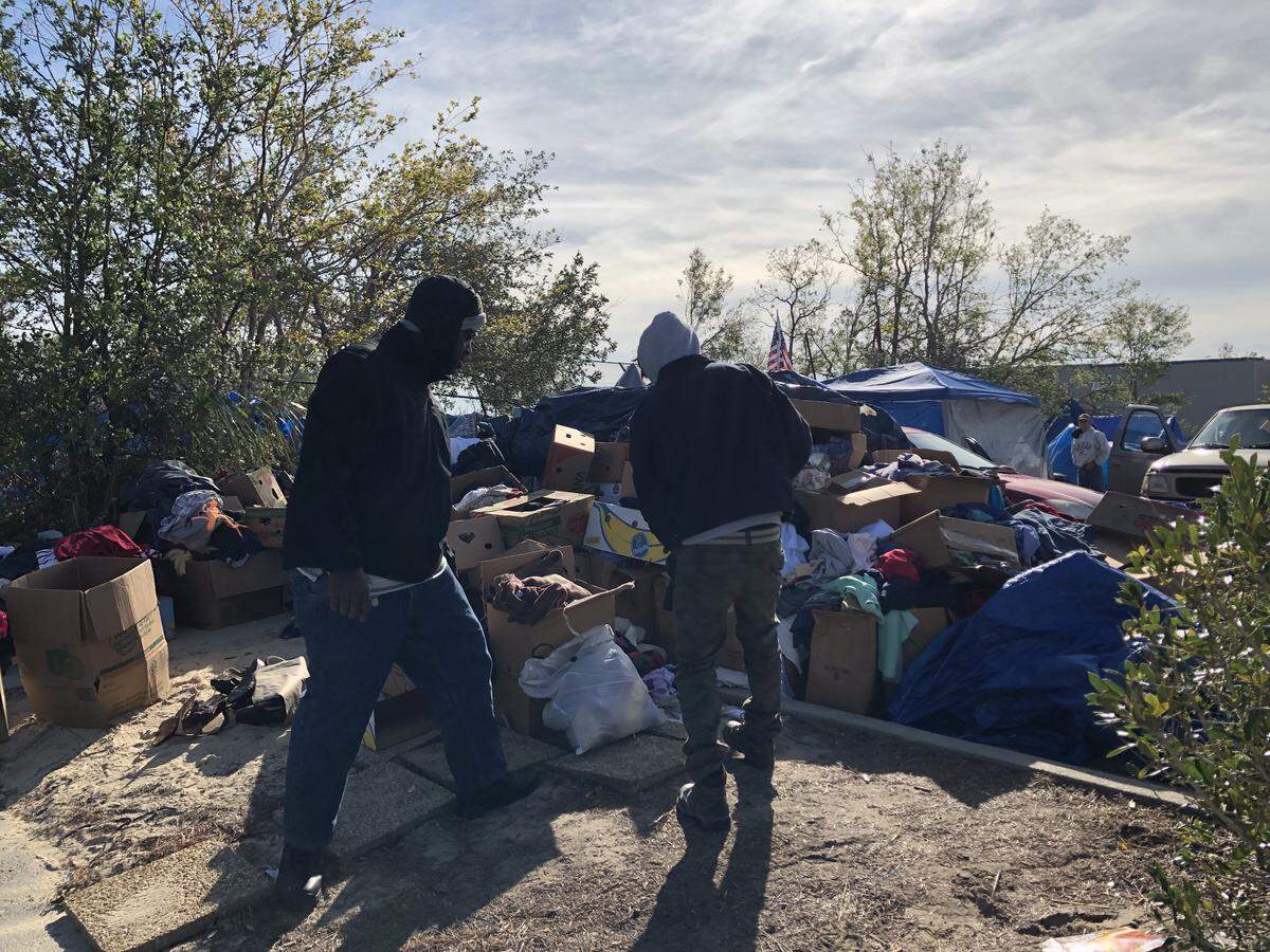 People search piles of donations left outside Forest Park Methodist Church in Panama City on Wednesday. The church parking lot has become a tent site for about 250 people after Hurricane Michael slammed the Panhandle on Oct. 10.