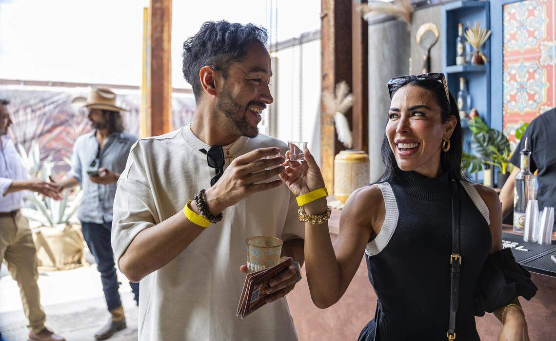 Diego Sandoval (i) y Jovanna Correa brindan durante su visita a Tequila Town. 