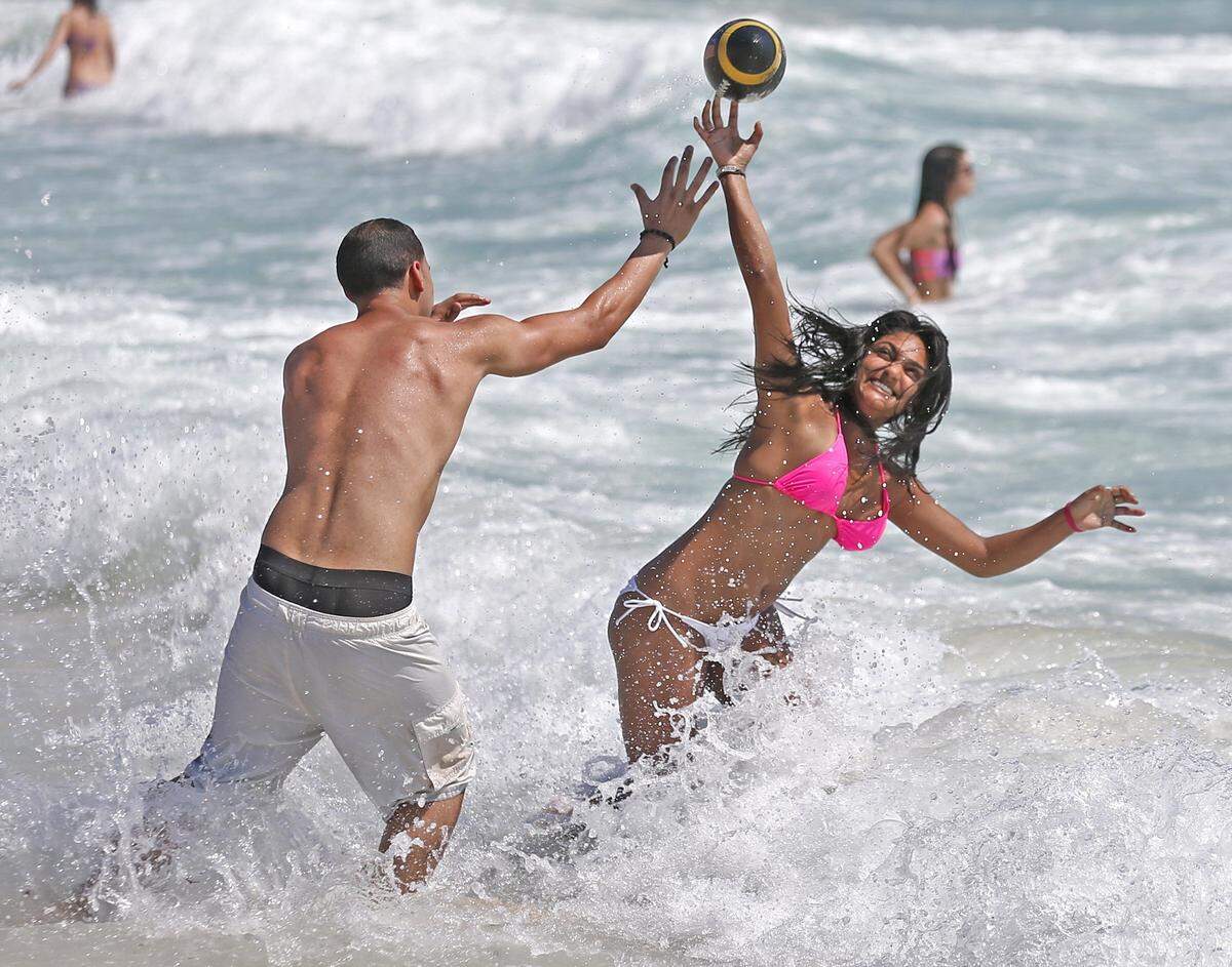 Mike Sierra, 21, and Larissa Macko, 21, spring breakers from the University of Central Florida, play ball on South Beach on Tuesday, March 10, 2015.