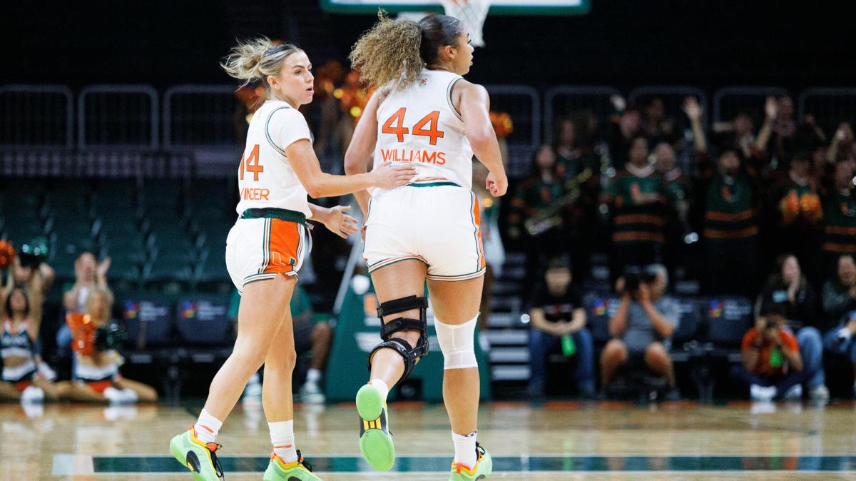 Miami Hurricanes guard Haley Cavinder (14) taps forward Cameron Williams (44) on the back after a play during the third quarter of a basketball game against the Wake Forest Demon Deacons on Sunday, Feb. 23, 2025, at Watsco Center in Coral Gables, Fla. The Hurricanes won 62-60.