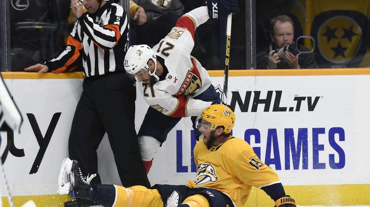 Florida Panthers center Vincent Trocheck (21) and Nashville Predators center Calle Jarnkrok (19), of Sweden, battle for the puck as referee Chris Rooney (5) tries to get out of the way during the first period of an NHL hockey game, Saturday, Oct. 19, 2019, in Nashville, Tenn.
