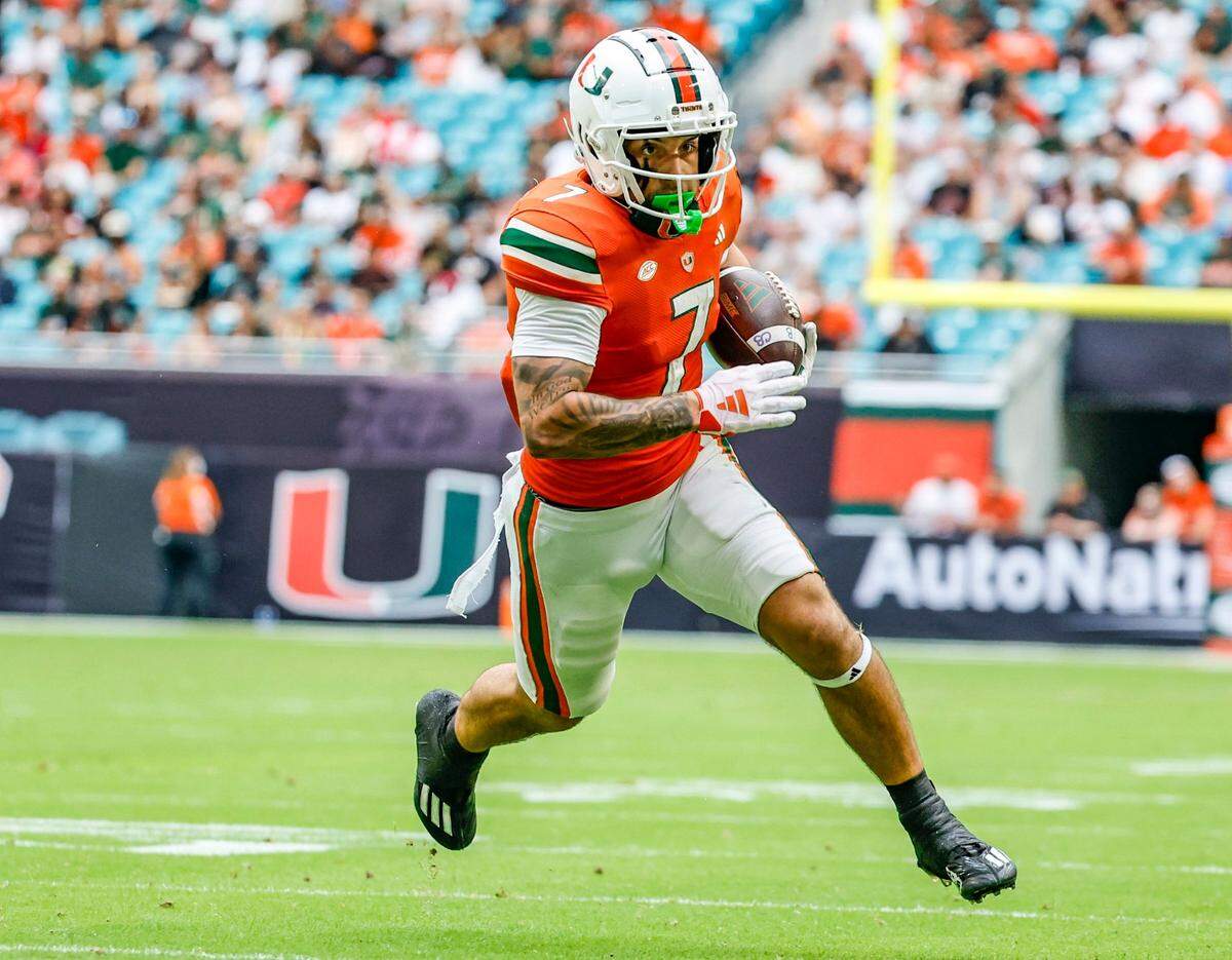 Miami Hurricanes wide receiver Xavier Restrepo (7) scores in the first half against the Louisville Cardinals on Saturday, November 18, 2023.
