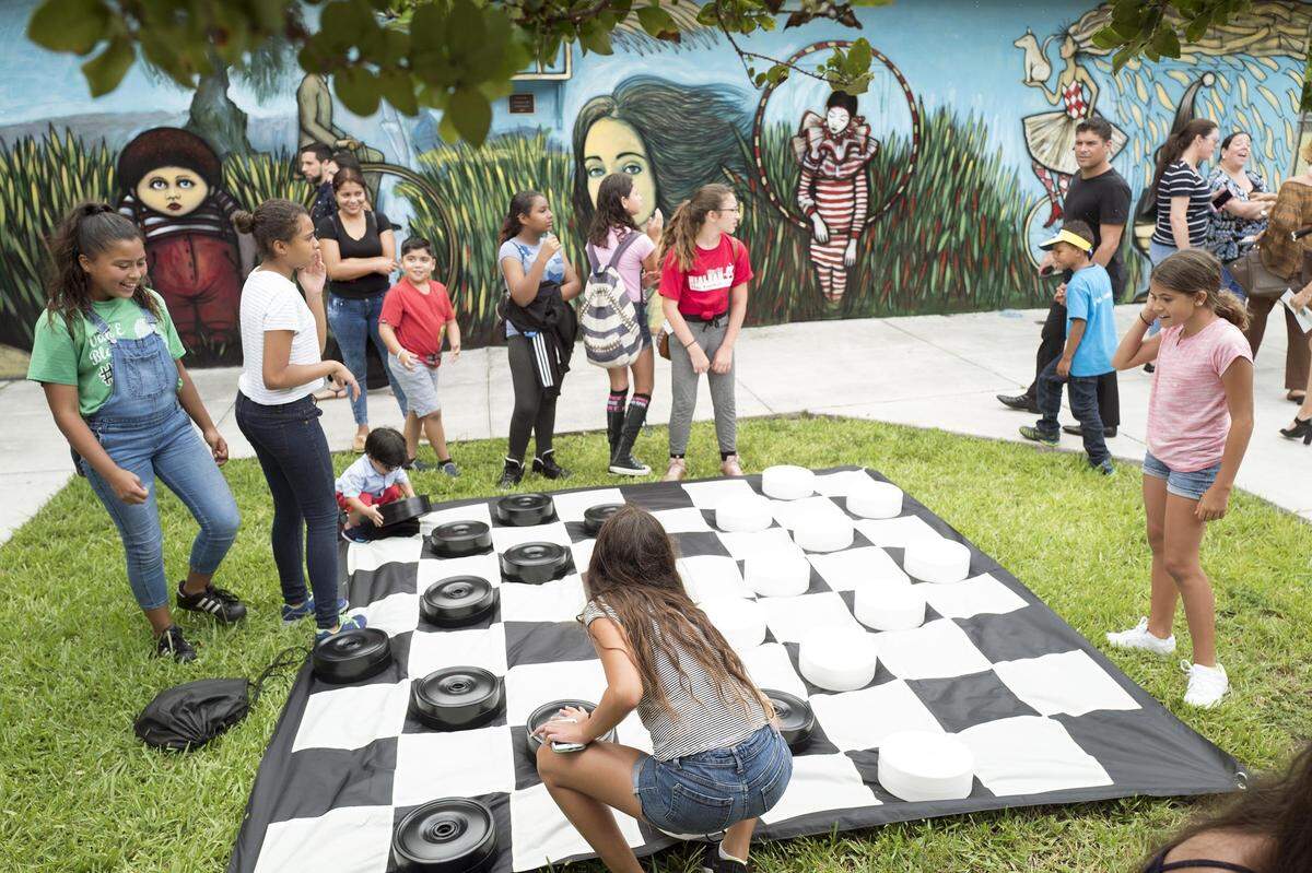 Children play a huge game of checkers at Hialeah’s new Domino Park on Thursday, July 12, 2018.
