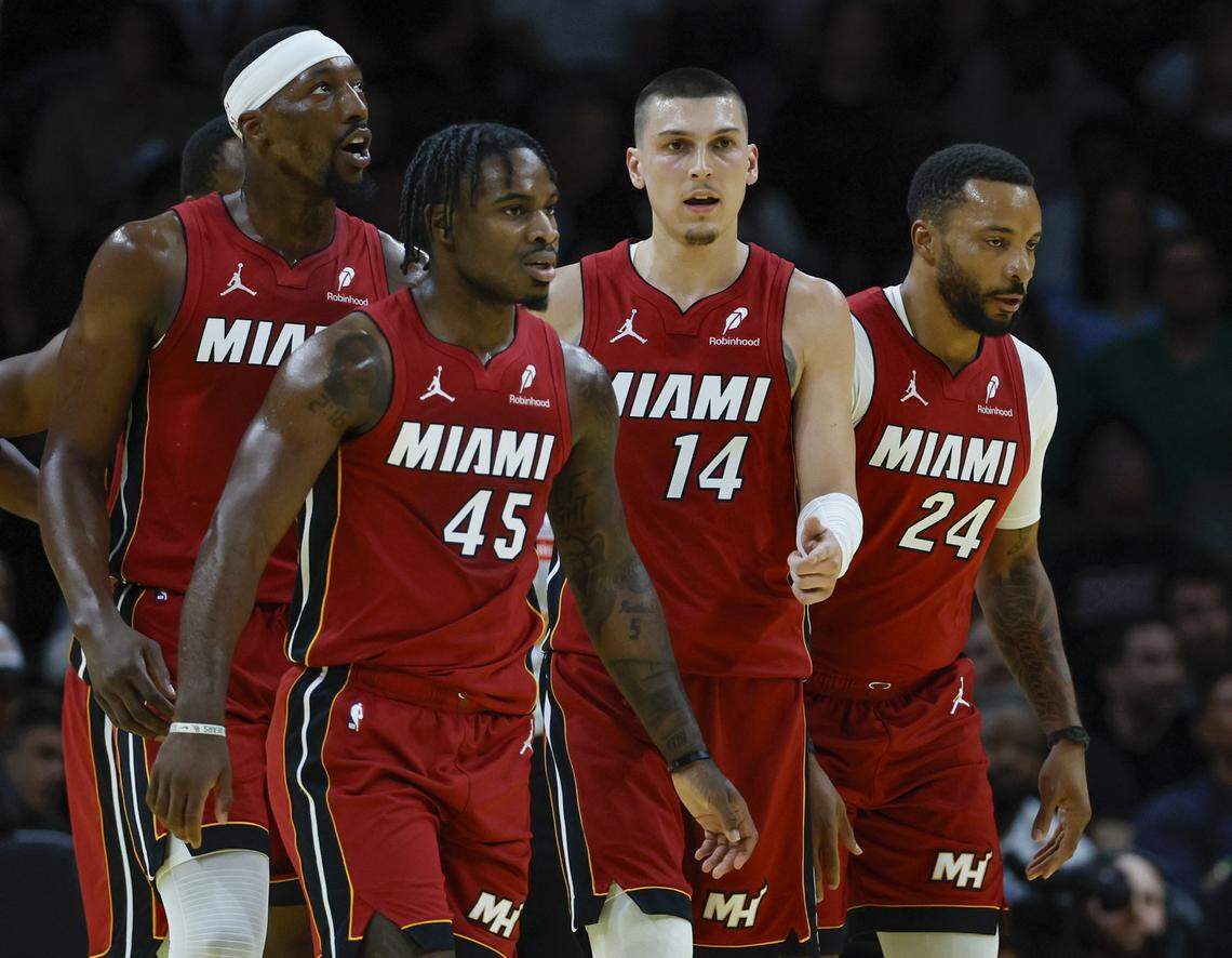 Miami Heat center/forward Bam Adebayo (13), guard Davion Mitchell (45), guard Tyler Herro (14), and guard Norman Powell (24) walk together on the court during their NBA basketball game against the Milwaukee Bucks at Kaseya Center in Miami on November 26, 2025.