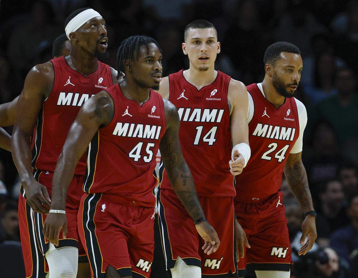 Miami Heat center/forward Bam Adebayo (13), guard Davion Mitchell (45), guard Tyler Herro (14), and guard Norman Powell (24) walk together on the court during their NBA basketball game against the Milwaukee Bucks at Kaseya Center in Miami on November 26, 2025.