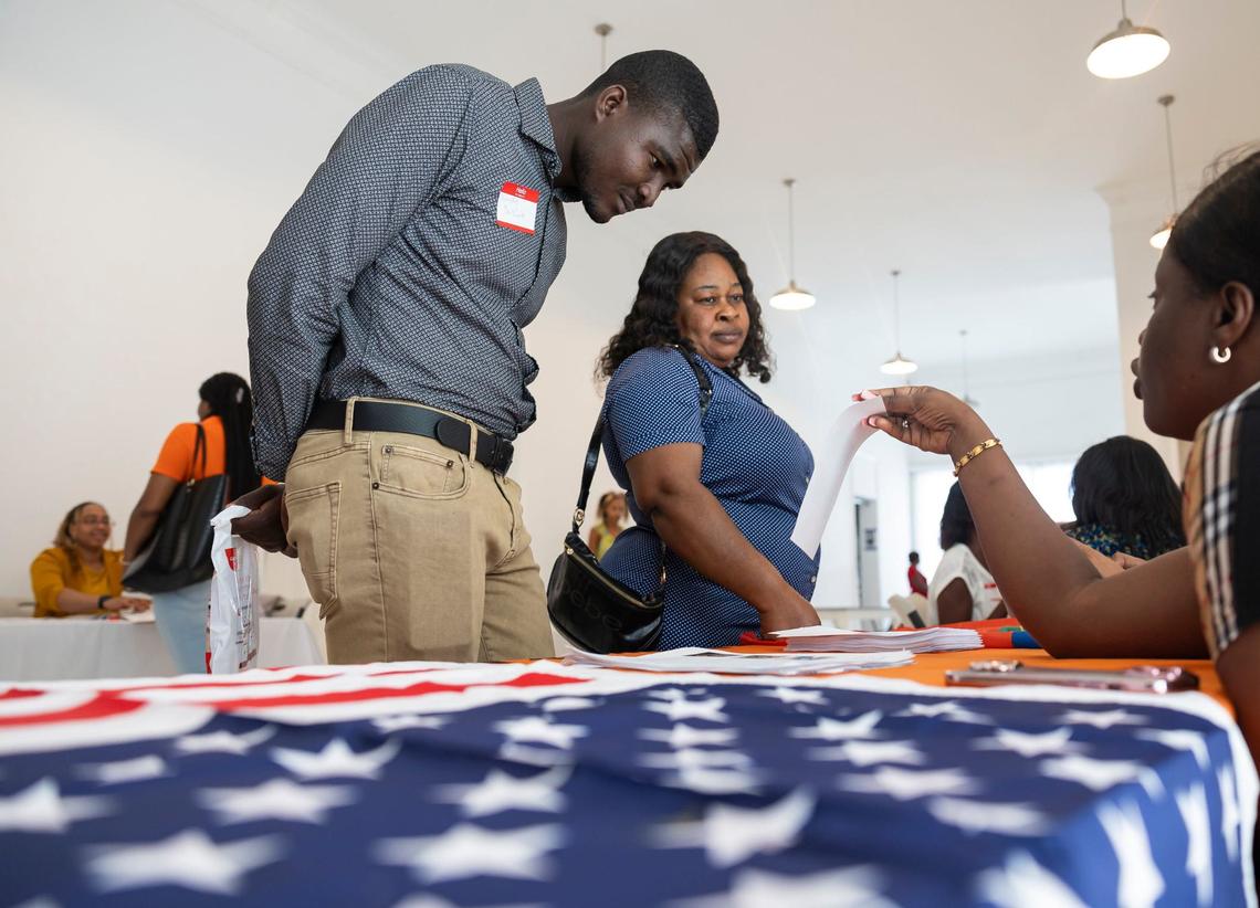 Kendy Duvine, 25, who arrived to the Florida Keys from Haiti on a boat, visits the Family Action Network Movement booth during a community resource fair at the Magic City Innovation District on Friday, May 31, 2024, in Miami, Fla. The fair aimed at helping recently arrived Haitians and other immigrants connect with health care providers and prospective employers.