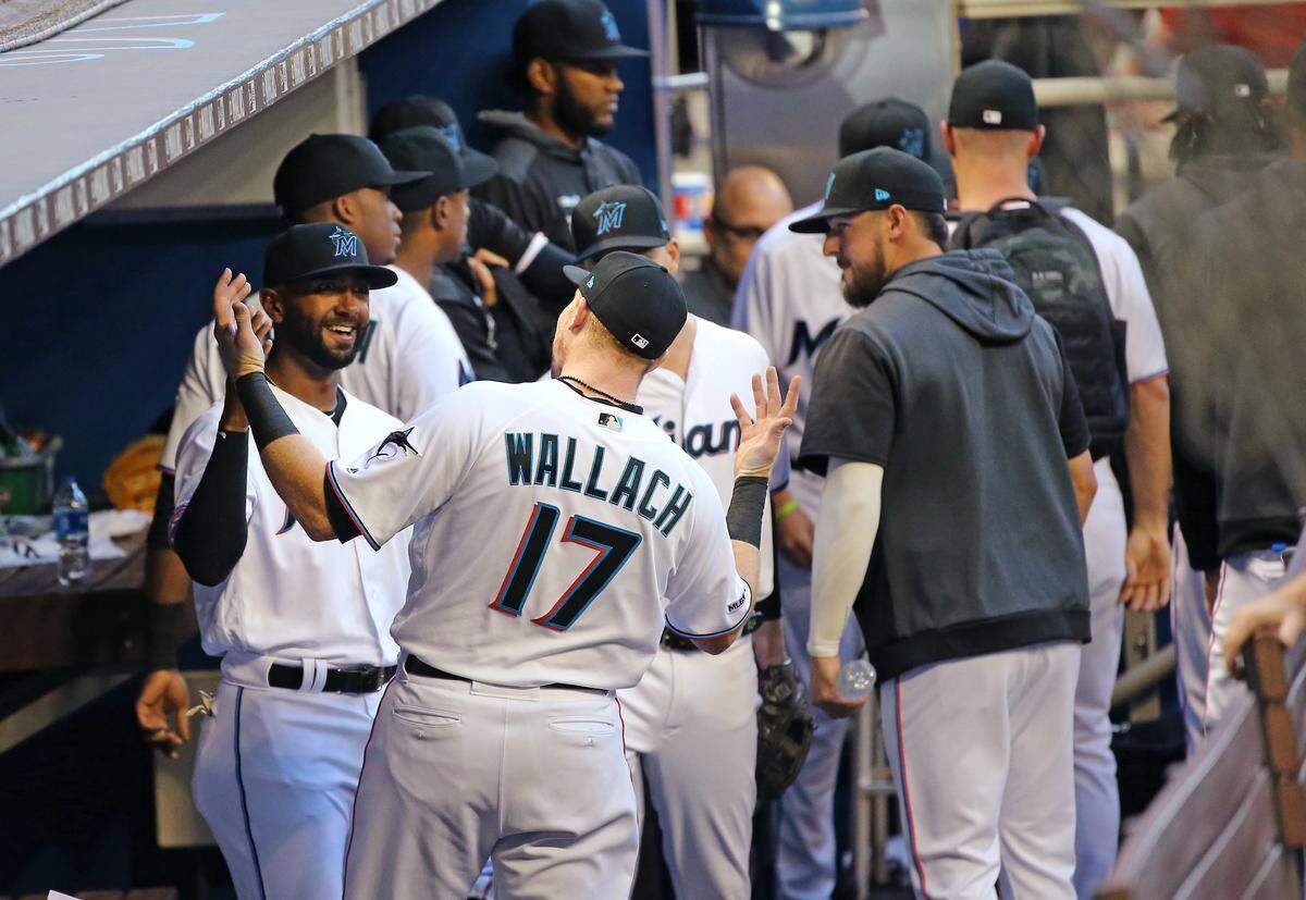 Miami Marlins right fielder Isaac Galloway (79) and catcher Chad Wallach (17) high fives at the dugout before the start of Major League Baseball game against the Chicago Cubs at Marlins Park in Miami, Tuesday, April 16, 2019.