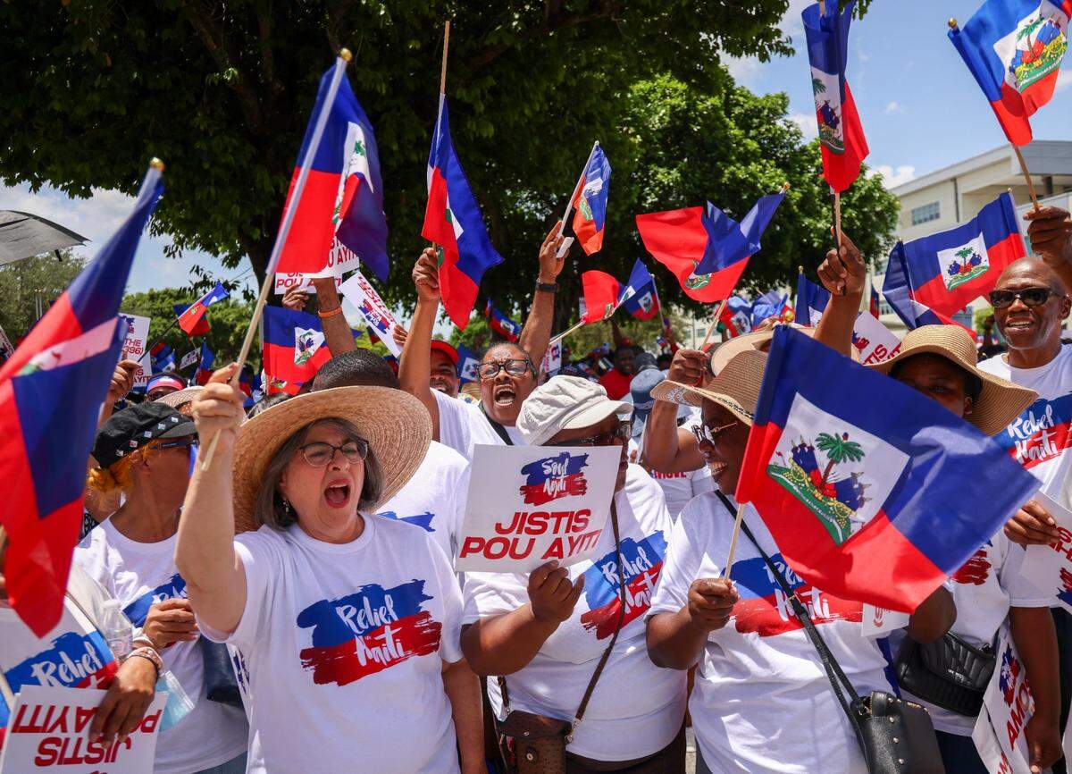 Miami-Dade County Mayor Daniella Levine Cava, left, joins in the waving of Haitian flags and chants of Haitian support as North Miami residents and members of the South Florida Haitian community gathered at North Miami High School for the start of the march. The march was in solidarity with Haitians rallying in other major American cities across the United States and the world on Sunday, July 9, 2023 to demand “Relief for Haiti.”