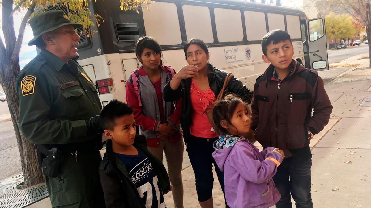 In this Thursday, Nov. 29, 2018 photo, a migrant family from Central America waits outside the Annunciation House shelter in El Paso, Texas, after a U.S. Immigration and Customs Enforcement officer drops them off. Volunteer shelters along the U.S.-Mexico border say they are preparing for an expected surged of new immigrants seeking asylum in the U.S. who will need temporary housing as the holidays approach. (AP Photo/Russell Contreras)