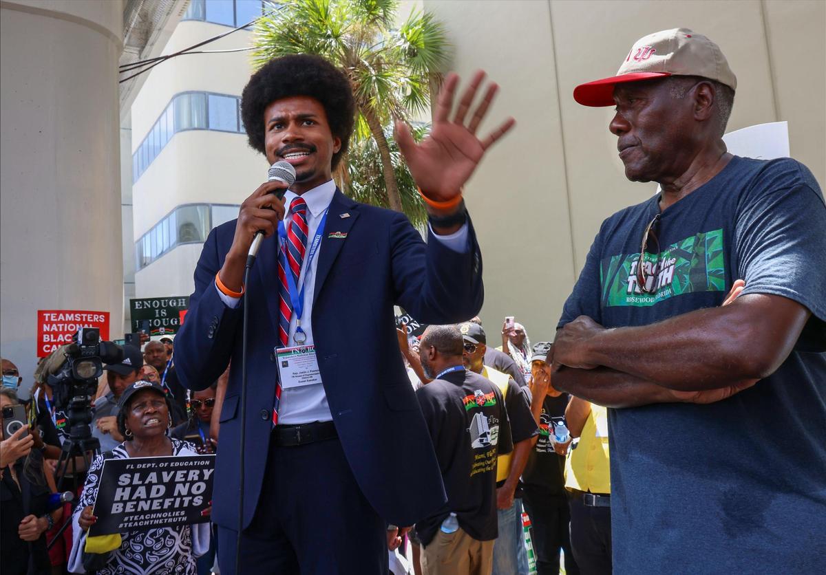El representante estatal demócrata de Tennessee, Justin Pearson (izquierda), aborda el impacto de las nuevas directrices educativas sobre la historia negra de la Florida en relación con la enseñanza de la esclavitud durante la manifestación frente al edificio administrativo de las Escuelas Públicas de Miami-Dade, el miércoles 16 de agosto de 2023. Unas 350 personas protestaron contra los nuevos estándares de historia afroamericana aprobados por el estado en julio. A la derecha, Marvin Dunn.