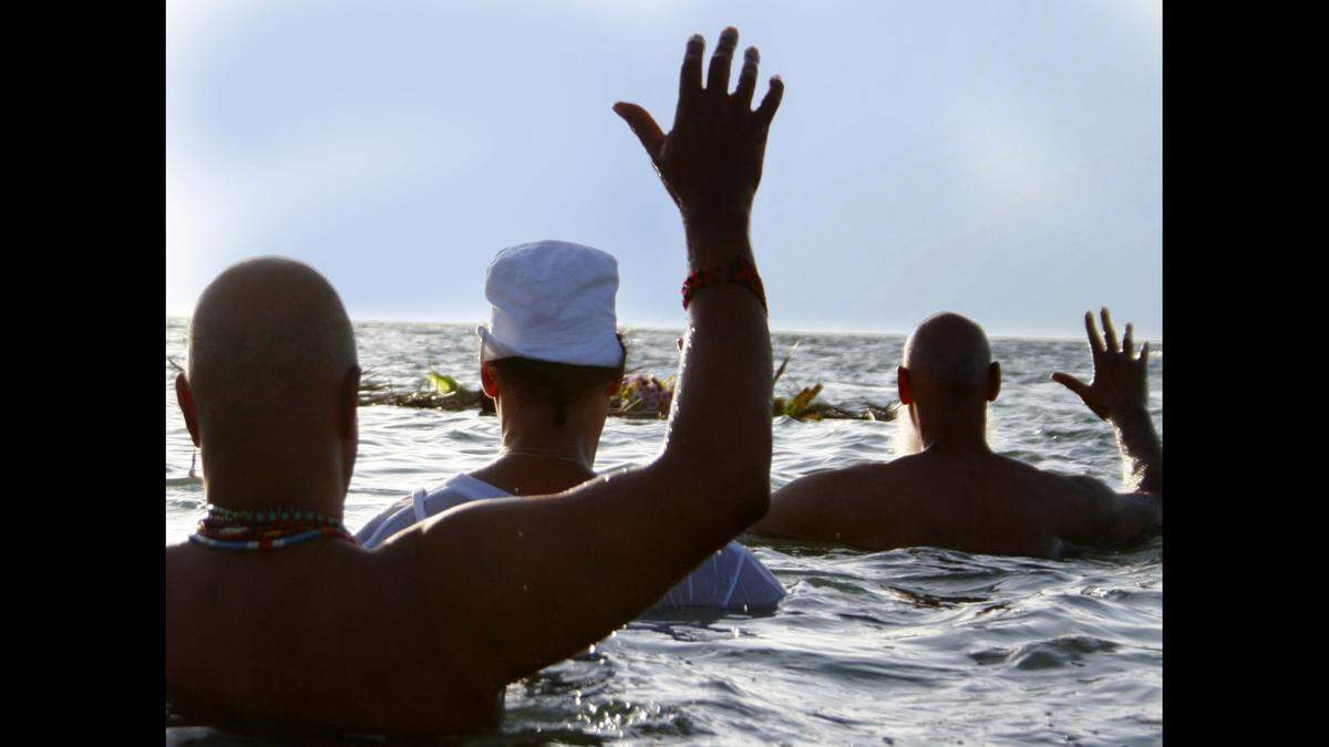 Omowale Osunkoya, center, Ricardo Martinez and Dinizulu Gene Tinnie, right, salute the offerings that the ocean takes away during the Annual Sunrise Ancestral Remembrance of the Middle Passage on June 17 , 2006. The ceremony honors the land and the Native populations as well as the memory of the millions who perished during the forced ocean crossing over the centuries.