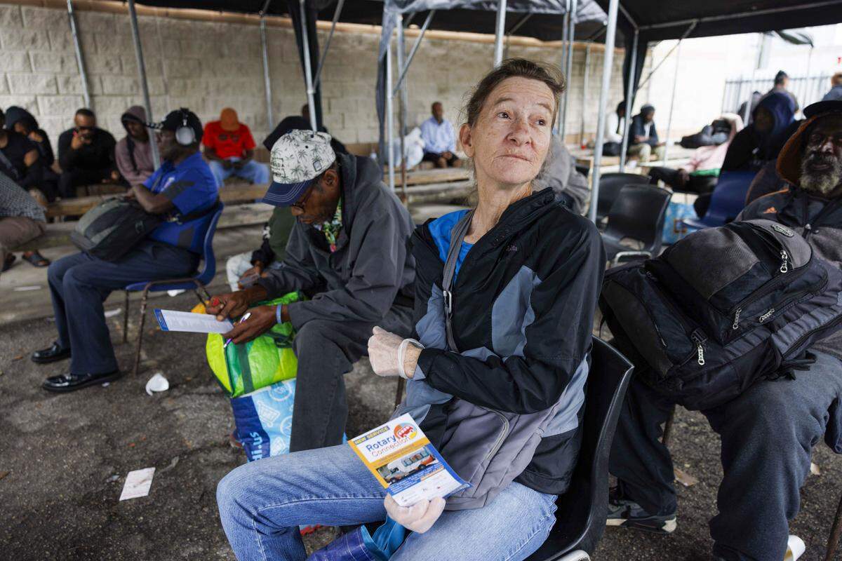 Sue Marsh receives a Rotary Connection bus schedule,a nonprofit initiative that offers free bus transportation to social services around the city, while waiting at LifeNet4Families on Monday, Jan. 12, 2026, in Fort Lauderdale, Fla.