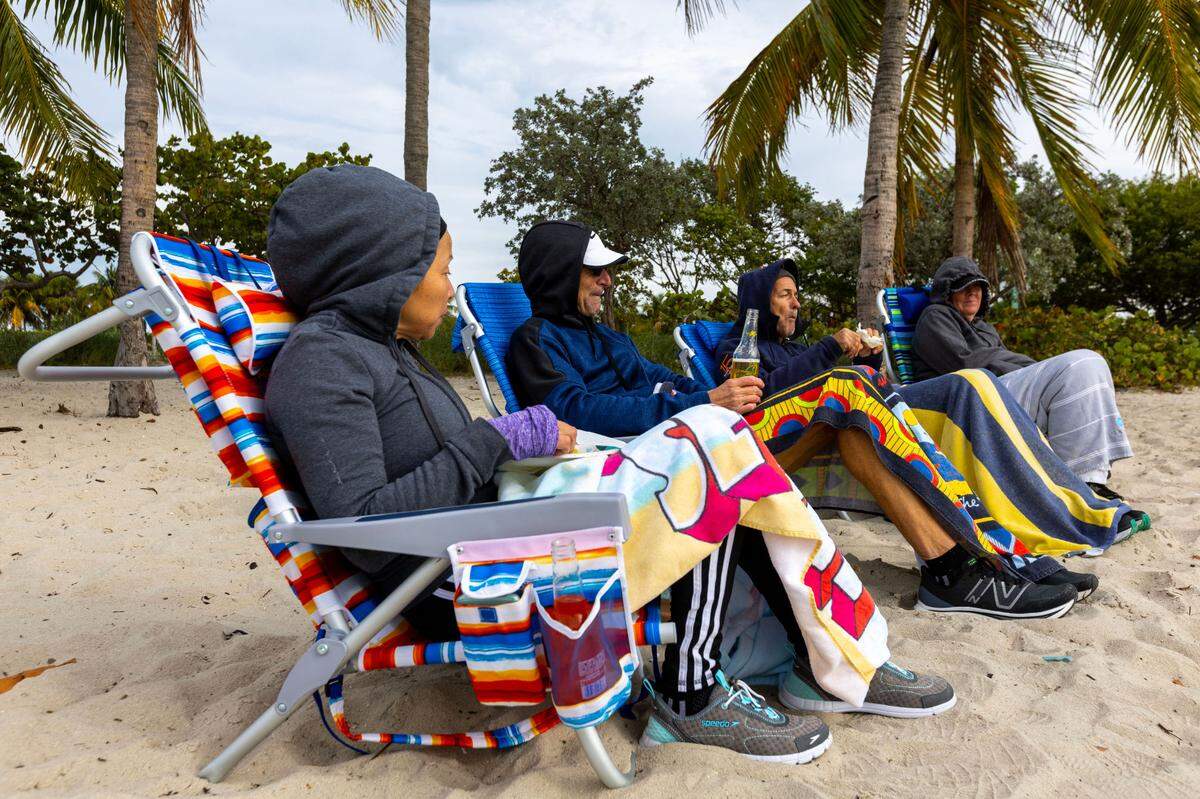 A group of runners take their traditional post-run snack break at Key Biscayne Dog Beach in Miami, Florida, on Saturday, December 24, 2022.