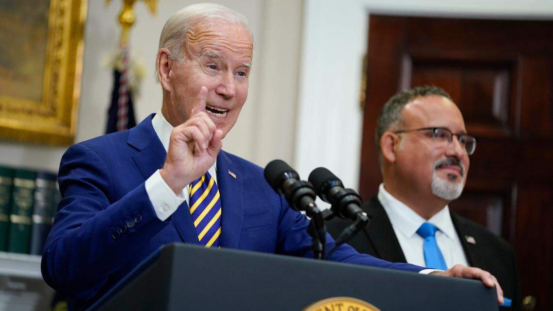 President Joe Biden speaks about student loan debt forgiveness in the Roosevelt Room of the White House, Wednesday, Aug. 24, 2022, in Washington. Education Secretary Miguel Cardona listens at right. (AP Photo/Evan Vucci)