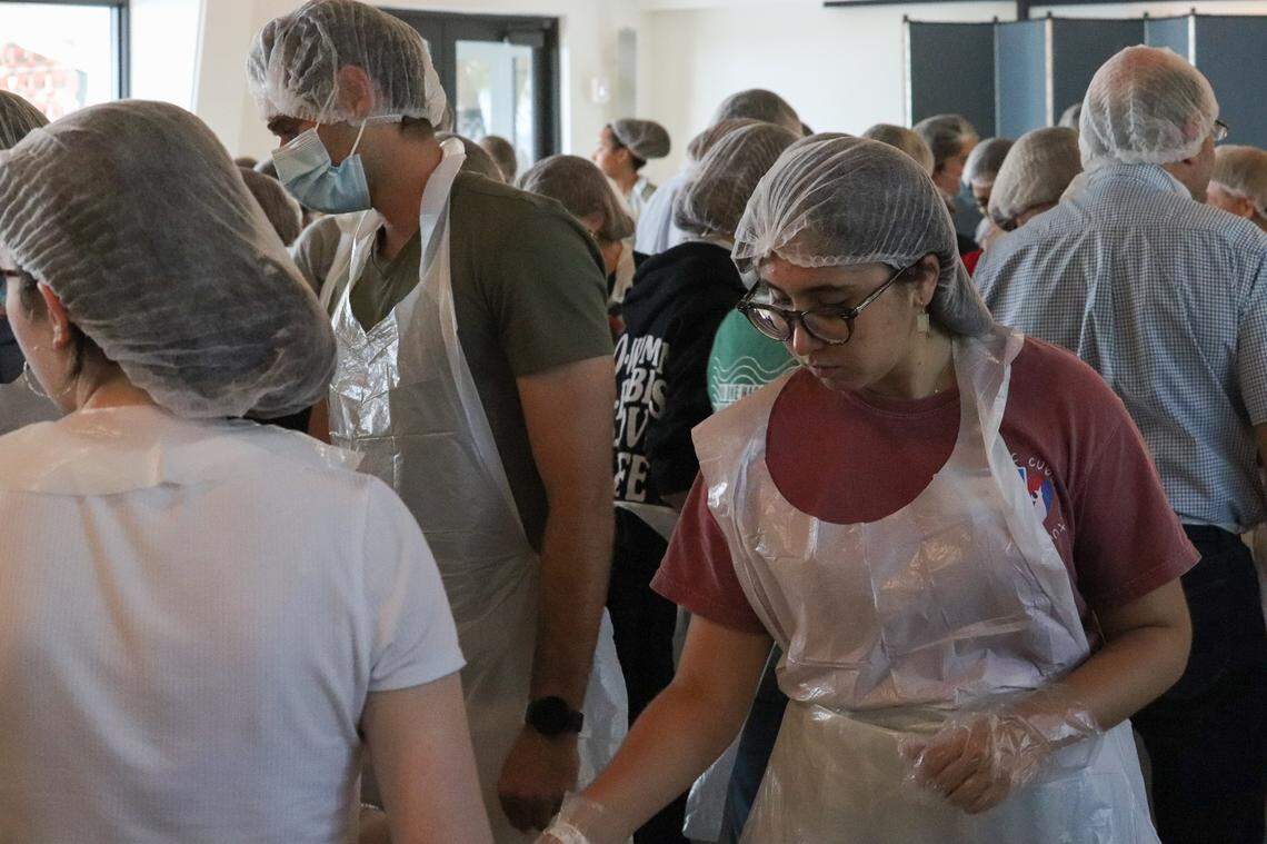 Giselle De La Rua, 22, a University of Miami alumna and member of St. Augustine’s young adult group helps prepare boxes of food at St. Augustine Church on Friday, April 1, 2022.