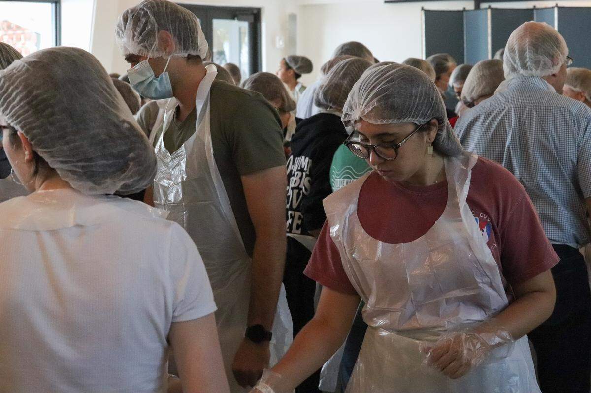 Giselle De La Rua, 22, a University of Miami alumna and member of St. Augustine’s young adult group helps prepare boxes of food at St. Augustine Church on Friday, April 1, 2022.
