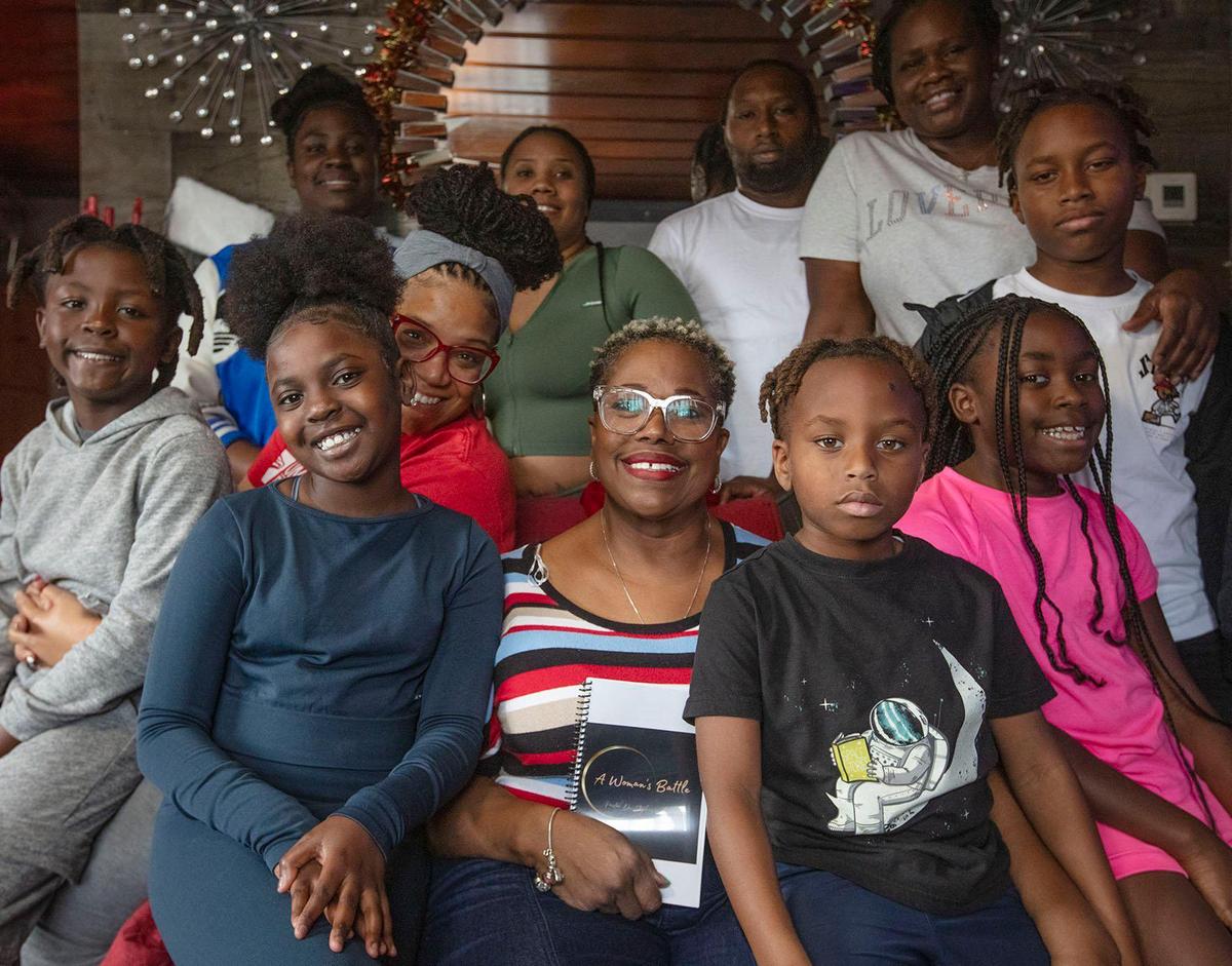 Stephanie Handford, sitting, center, who has multiple sclerosis poses with her family for the Wishbook in Miami on Saturday December 7th., 2024.