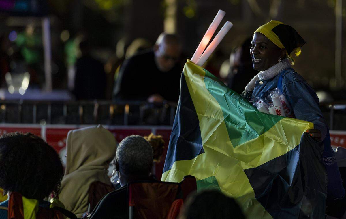 Frances Penha, with Spiced Hutt, sells flags and glow sticks during the Reggae Genealogy music festival at Volunteer Park on Saturday, Feb. 7, 2026, in Plantation, Fla.