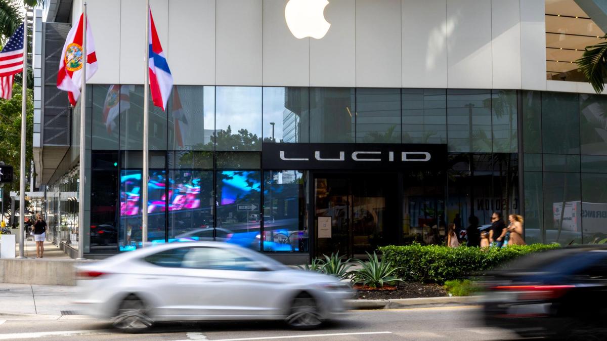 Pedestrians and vehicles pass by the Brickell Studio showroom for Lucid, a new high-end electric car company, within Brickell City Centre in Miami, Florida, on Friday, December 2, 2022. The studio lit up some animated artwork from the window in recogntion of Art Basel 2022.