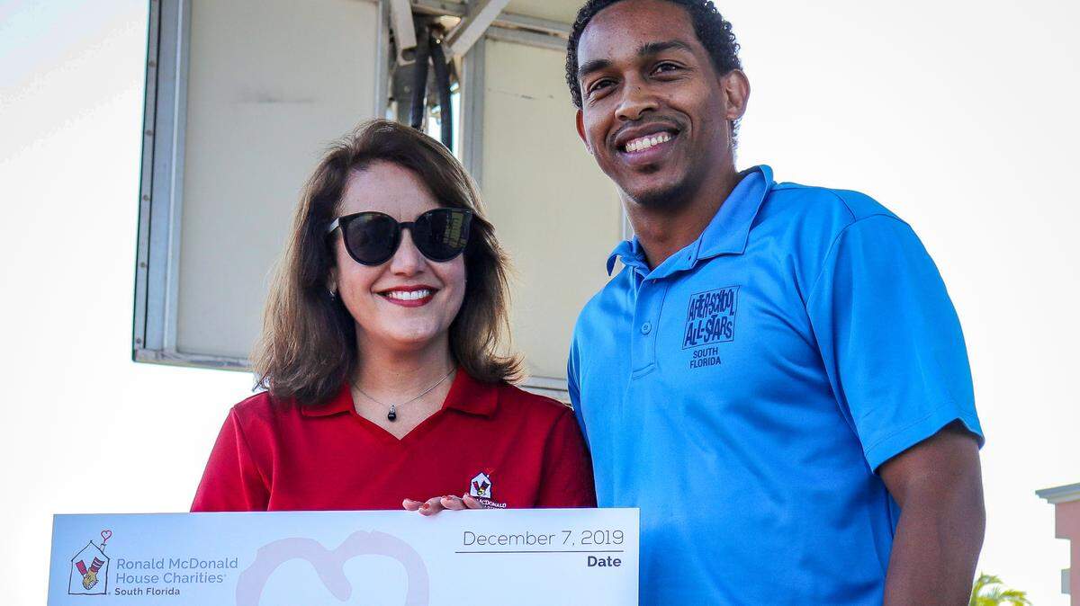 Soraya Rivera-Moya, executive director of the Ronald McDonald House Charities of South Florida, presents a check to Sean Prospect, executive director of After-School All-Stars South Florida at the sixth annual Superfest held at Florida International University.