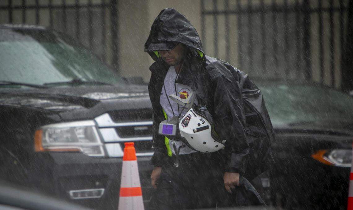 Surfside, Florida, June 30, 2021 - A member of a search and rescue team makes his way to the site of the collapse under a heavy downpour.