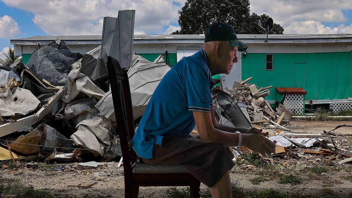 Santos Varela, 71, sits in his carport next to a pile of scrap metal and other debris from what was his neighbor’s mobile home in the Li’l Abner Mobile Home Park in Sweetwater, Florida, on Monday, May 19, 2025. Varela has been feeling the strain of his recent chemotherapy treatments, compounded by the looming threat of eviction from his home.