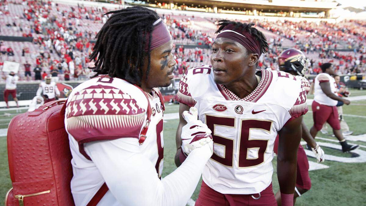 FSU player Stanford Samuels III wears the “turnover backpack” as he celebrates with teammate Emmett Rice after their game against the Louisville Cardinals on Sept. 29, 2018.