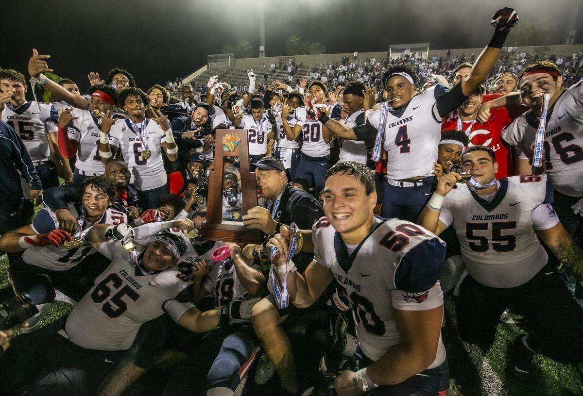 Columbus celebrates with the championship trophy as they win 21-20 on a two point conversion in the final seconds of the fourth quarter as the Columbus Explorers defeats Apopka for the Class 8A FHSAA State Championship at Daytona Stadium in Daytona Beach on Friday, December 13, 2019.