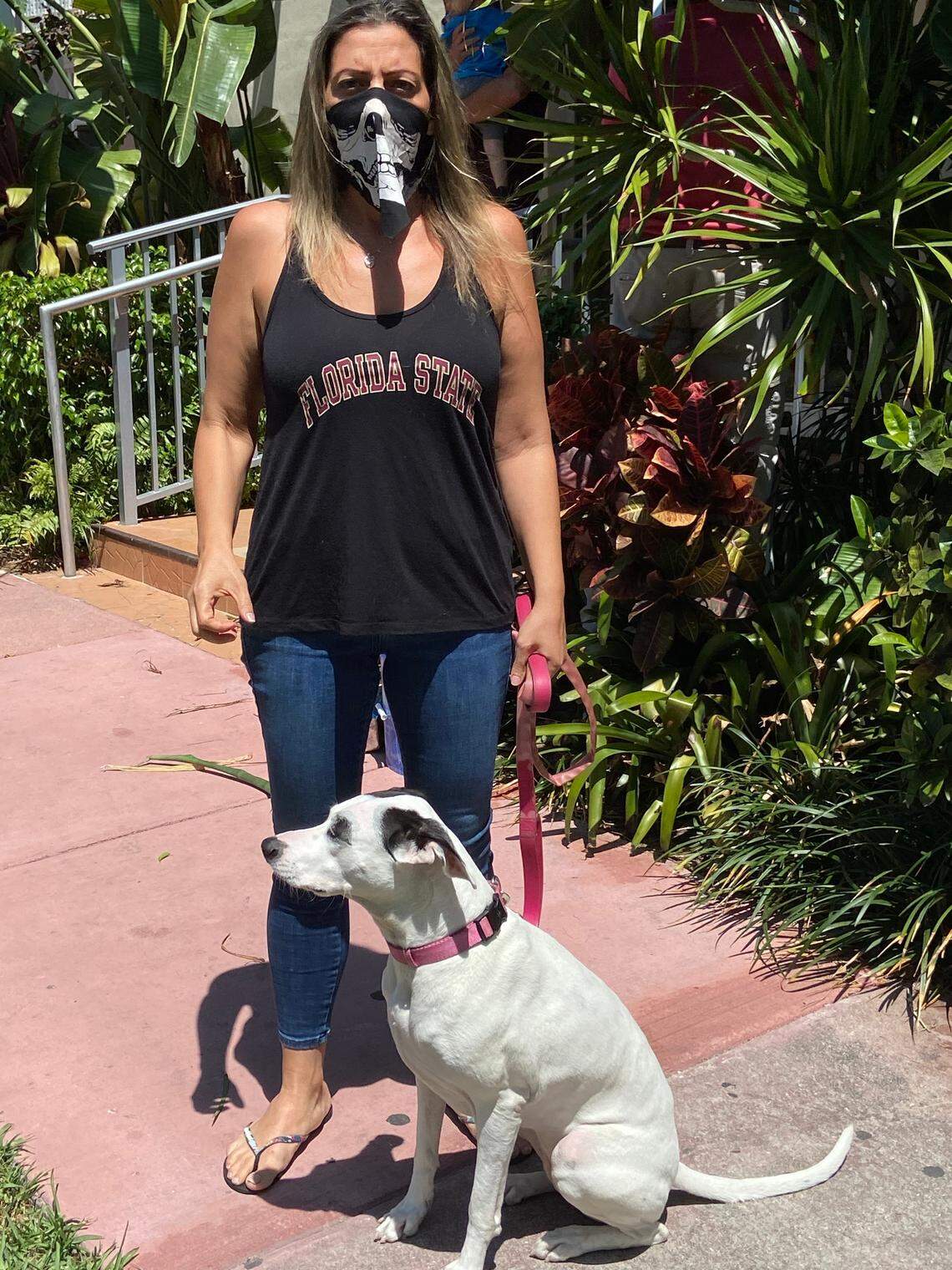 Monica Matteo Salinas, a South Beach resident, wears a Halloween mask to walk her 3-year-old mixed-breed dog Luna.