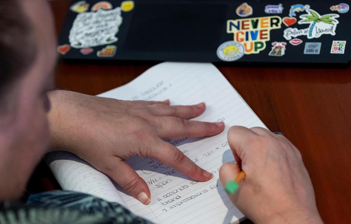 Melody McDonald writes notes as she attends a childcare business seminar at Nova Southeastern University on Saturday, Nov. 16, 2024, in Davie, Florida. The seminar aimed to teach participants how to start and improve their childcare businesses operations.