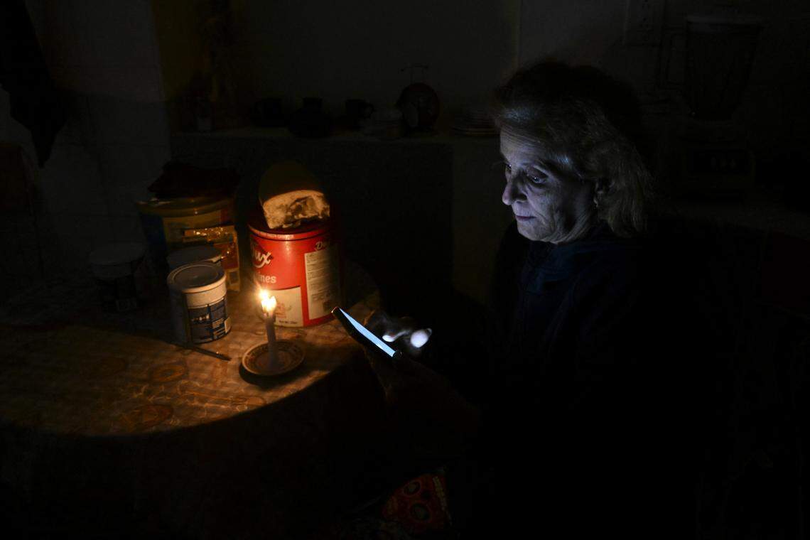 TOPSHOT - A woman checks her cellphone during a blackout in the Luyanó neighborhood of Havana on January 28, 2026. 