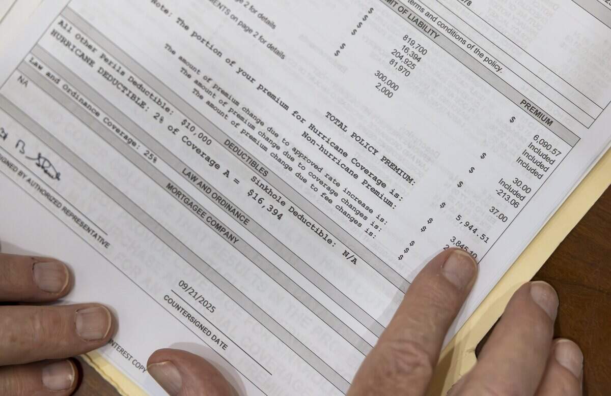 James Weidener looks over his homeowners insurance policy while sitting in his office on Saturday, May 30, 2026, in Coral Springs, Fla. Weidener opted out of homeowners insurance for nine years because of high costs but resumed coverage a couple of years ago.
