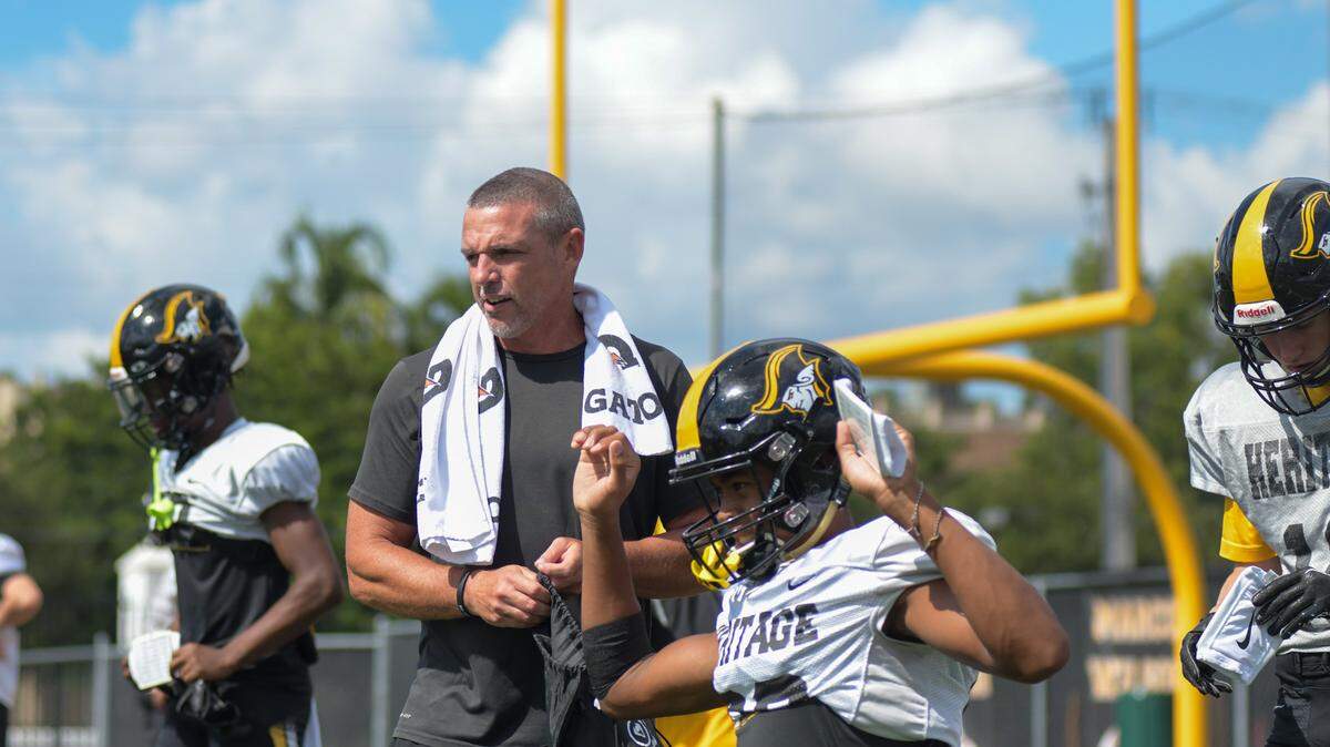 Plantation American Heritage football coach Mike Smith watches on as his team stretches at the start of practice on Wednesday, Aug. 17, 2022.