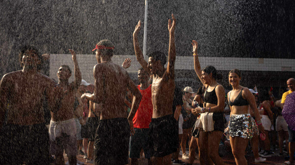 Fans of US singer Taylor Swift cool off as they queue outside the Nilton Santos Olympic Stadium before Swift’s concert, “Taylor Swift: The Eras Tour”, amid a heat wave in Rio de Janeiro on November 18, 2023.