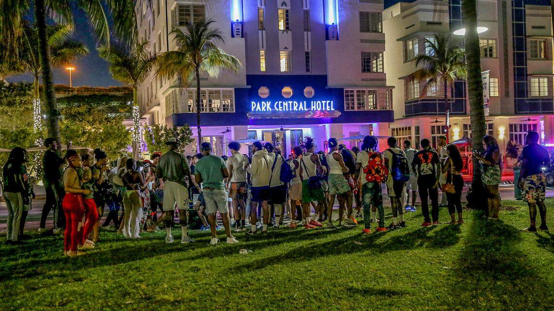 Spring breakers hang out in front of the Park Central Hotel, in Ocean Drive on Saturday night, March 26, 2022, hours before a midnight curfew, imposed by the City of Miami Beach for the South Beach area, due to two shootings the weekend before, that caused city officials to announce a “state of emergency”.