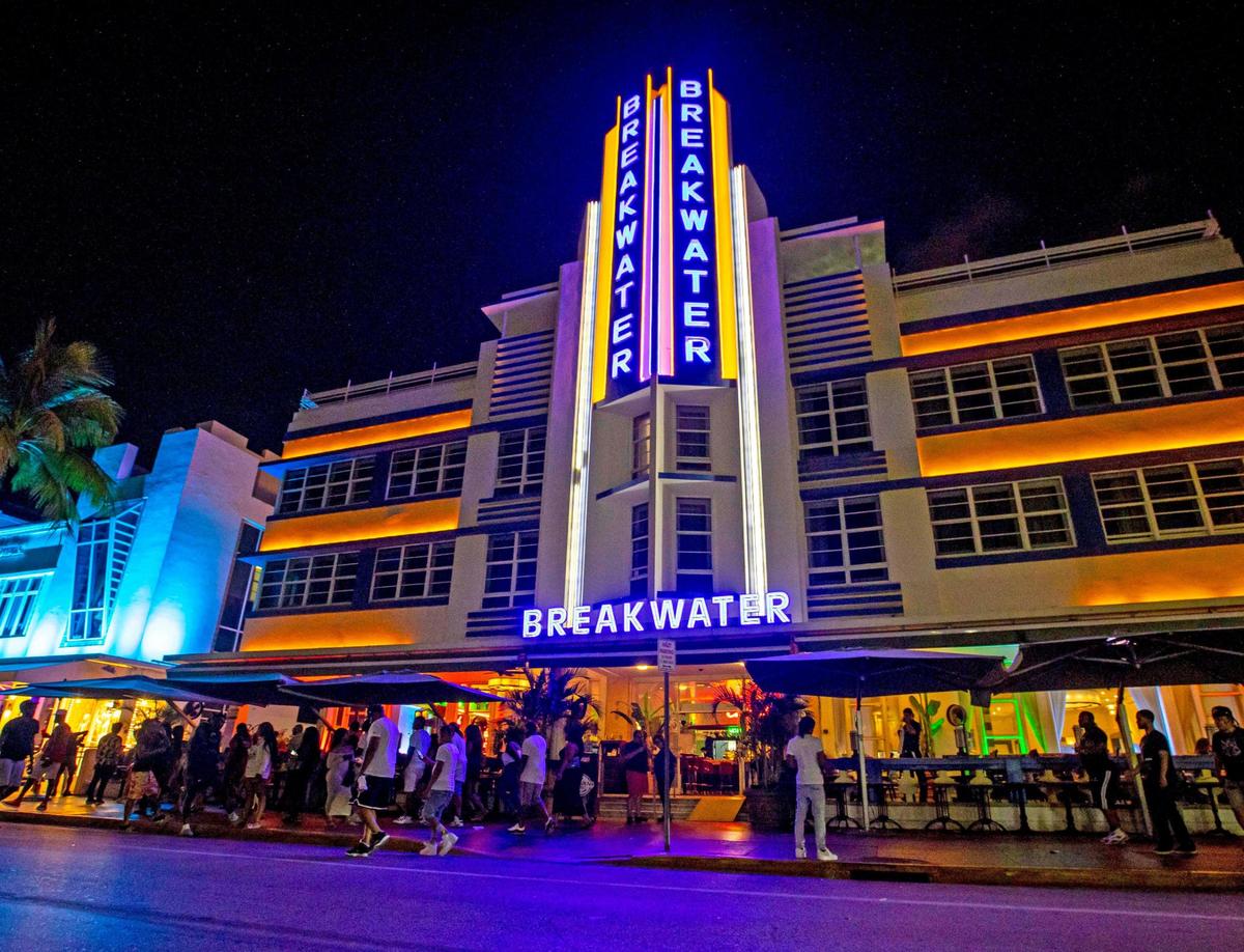 People pass the Hotel Breakwater South Beach as they walk Ocean Drive during the first day of Memorial Day Weekend in Miami Beach, Florida, on Friday, May 27, 2022.