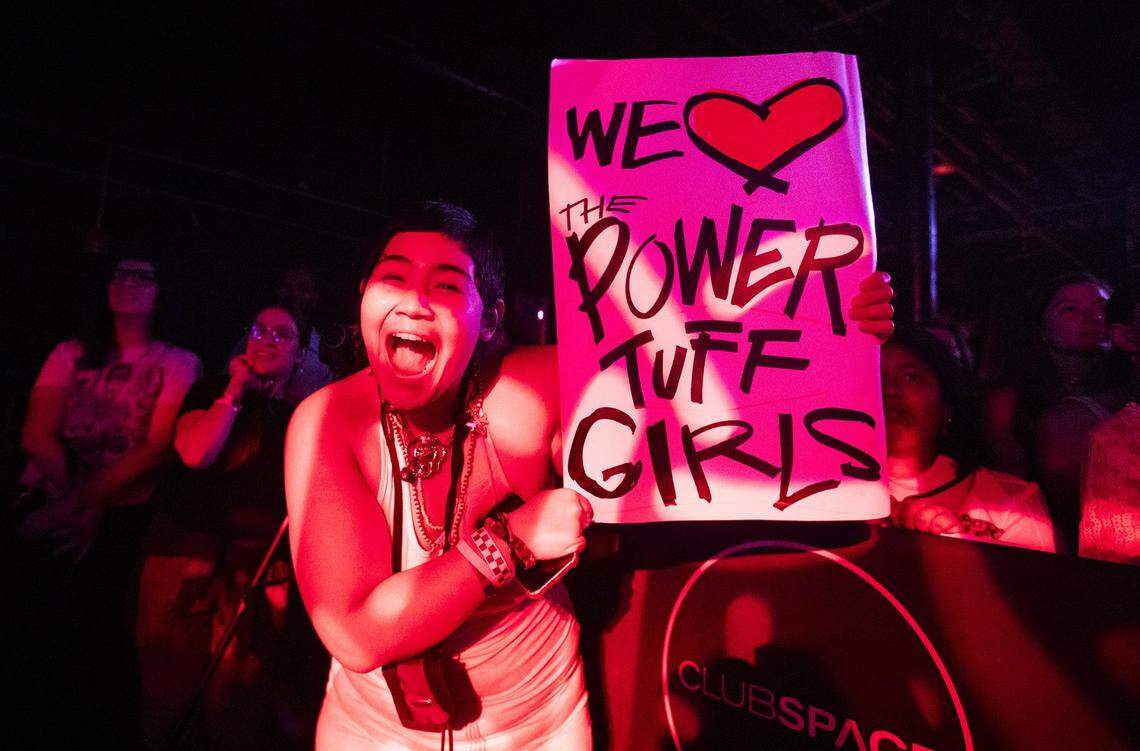 Samuel Herrera holds a sign with the name of her sister's band during the Miami Girls Rock Camp at The Ground at Space, Miami; on Saturday, August 2, 2025. The all-ages event featured live performances from 10 brand-new camper bands, showcasing original songs created during camp week.