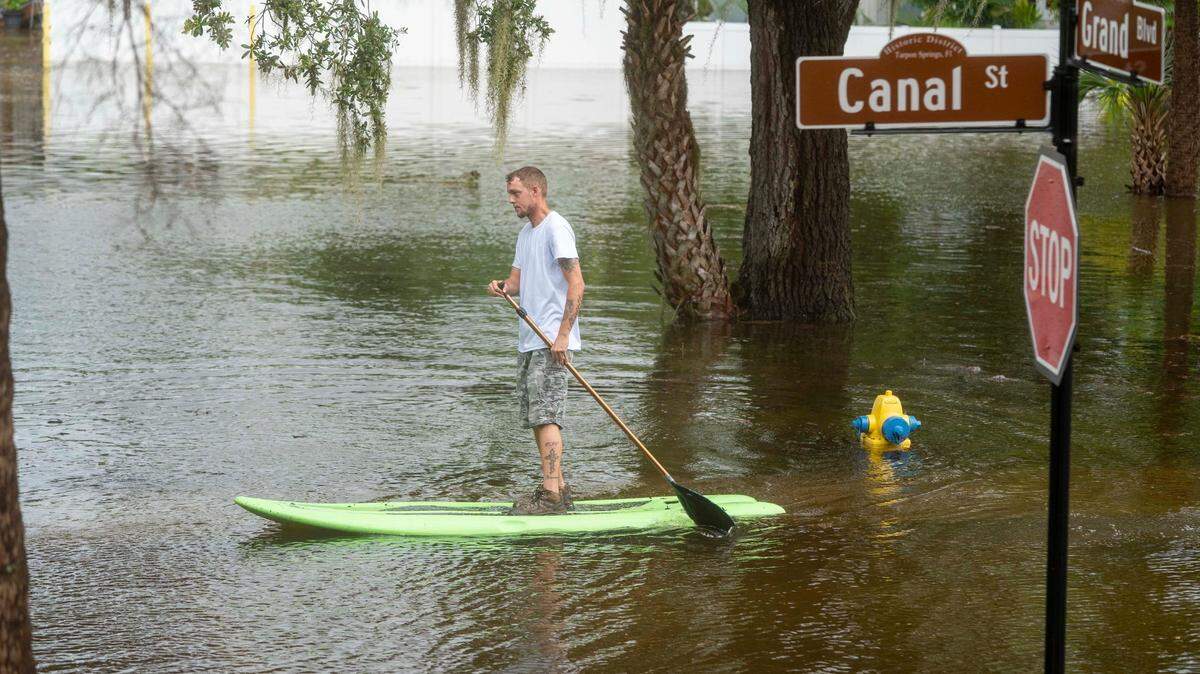 Chris Bodue paddles through his flooded neighborhood from Hurricane Idalia in Tarpon Springs, Florida on August 30, 2023.