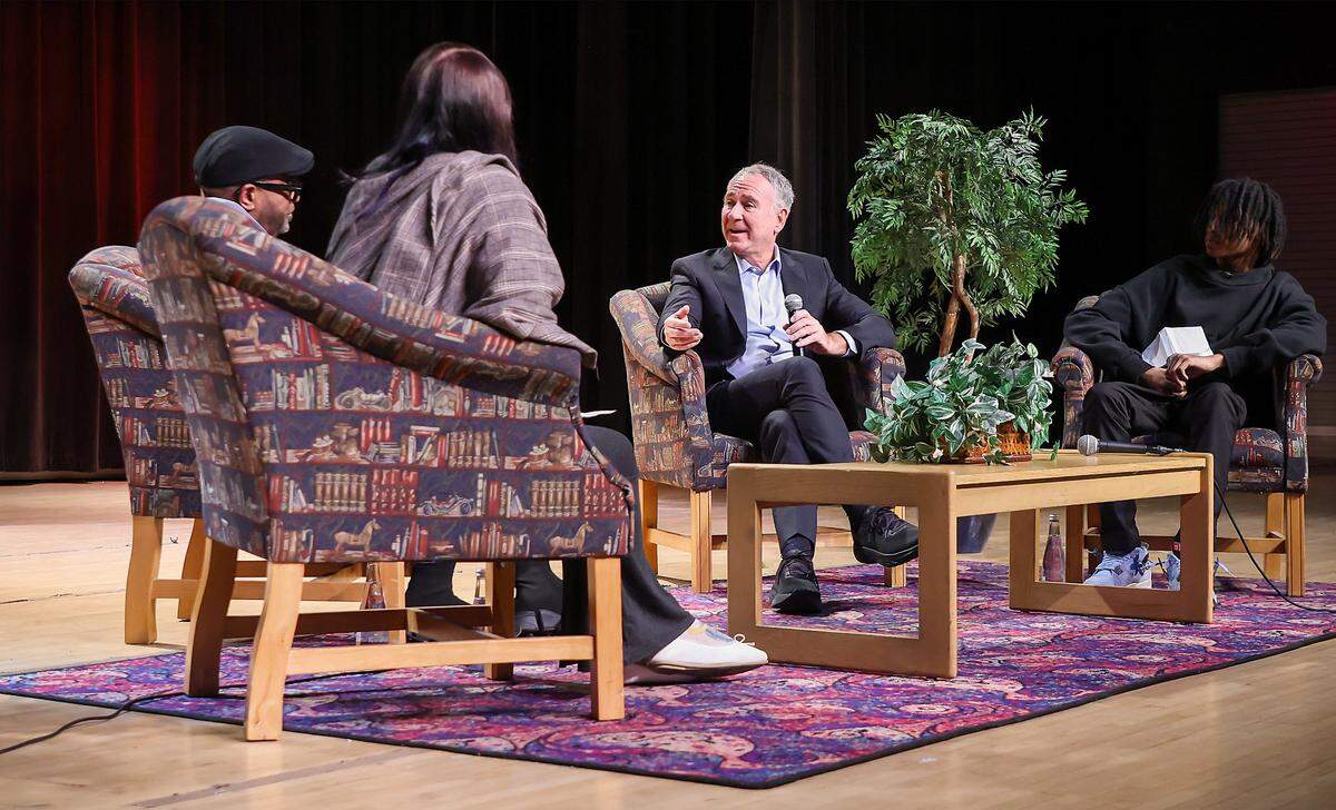 Ken Griffin, third from left, answers teacher Malik Padgett's question as he speaks with student SkyyLynn Windhauser, left, Padgett, and student Sebastian Mejia, right, during his visit to Booker T. Washington Senior High School on Tuesday, Feb. 24, 2026, in Miami, Florida.