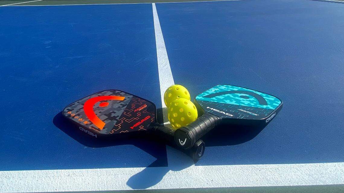 Pickleball paddles lying on an outdoor court.