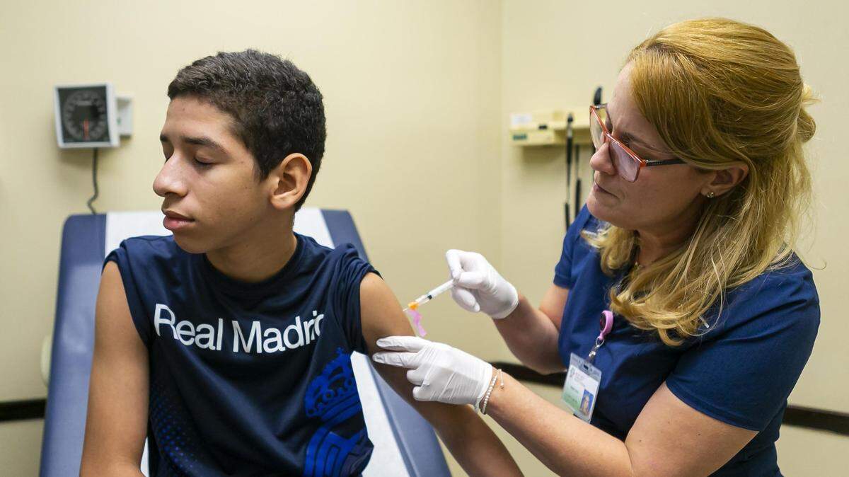 Cristian Benitez, 11, is given his immunization shots at the Back To School Health Fair at the Jessie Trice Community Health System in Miami, Florida, on Saturday, Aug. 17, 2019. The health fair offered attendees free dental screenings and immunization shots before the start of school the following week.