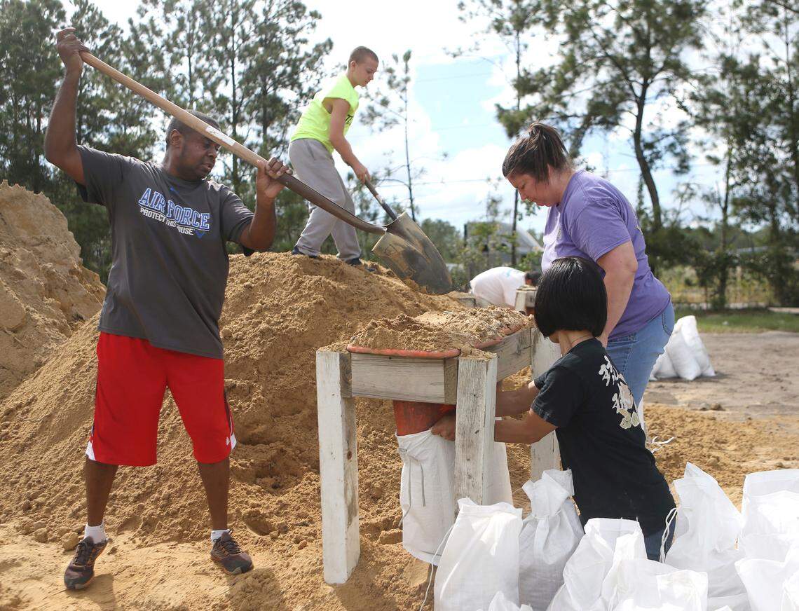 From left, Haskel Johnson, Daniel Tippett, Jennifer Tippett and Nobuko Johnson fill sand bags at the Lynn Haven Sports Complex in Lynn Haven in Bay County on Monday in advance of Hurricane Michael.
