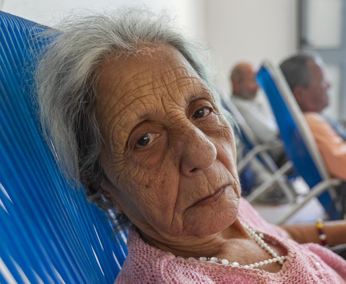 Ines María Viena Rodríguez, 80, sits on chair inside la Merced center in Old Havana, Cuba.