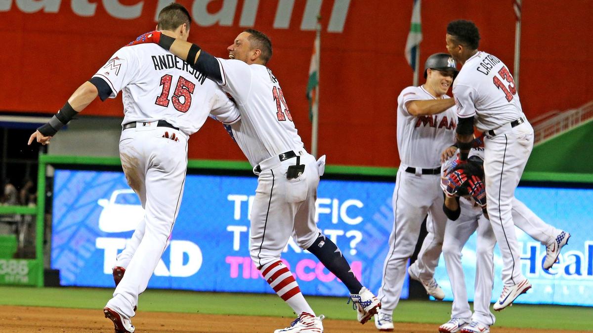 Miami Marlins Miguel Rojas (19) jumps on Brian Anderson (15) after he scored the winning run as J.T. Realmuto (11) and Starlin Castro (13) jump on Yadiel Rivera (2)  after he hit the RBI to drive Anderson to score as they defeat the Tampa Bay Rays at Marlins Park in Miami, Florida, July 2, 2018.