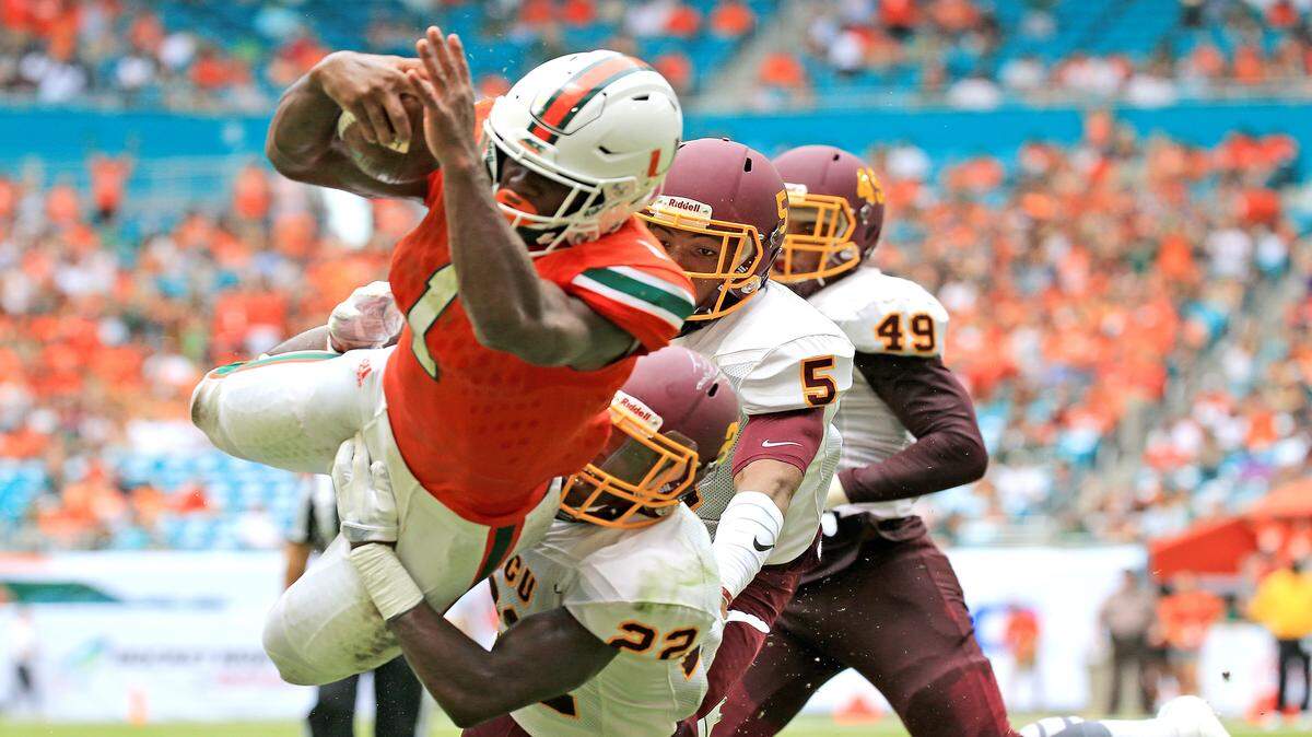 Miami Hurricanes running back Mark Walton (1) dives into the end zone to score in the second quarter as the University of Miami hosts Bethune-Cookman at Hard Rock Stadium on Saturday, Sept. 2, 2017.