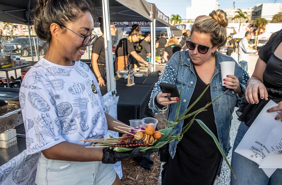 Ariane De Mesa, ofrece muestras de comida callejera filipina a los asistentes en la carpa del restaurante emergente So Sarap, durante el evento previo a la apertura de Smorgasburg Miami el nuevo mercado de alimentos al aire libre en Wynwood.