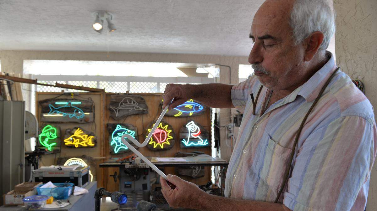 Steve Moser works with a neon tube, the same type of tube people used 100 years ago. Moser moved to Key Largo and makes neon signs. He crafted the original Panther Coffee neon sign in Wynwood, and his neon work has appeared in films, including the Bruce Willis film, “Mercury Rising.”