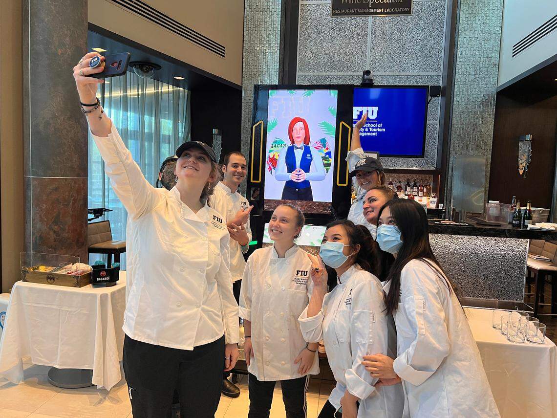 Students at FIU’s Chaplin school of Hospitality & Tourism Management take a selfie with Cecilia, the robot bartender.