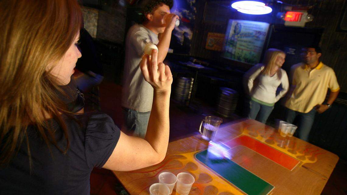 In happier times, customers play beer pong atop the UM logo.