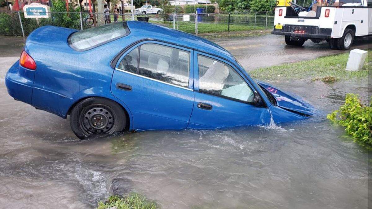 The sinkhole at North 58th Avenue and Thomas Street starts to swallow a car.